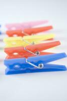 a pile of colorful clothes pegs on a white surface photo