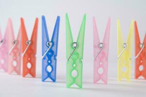 a pile of colorful clothes pegs on a white surface photo