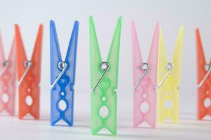 a pile of colorful clothes pegs on a white surface photo