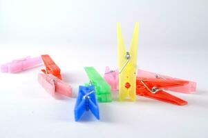 a pile of colorful clothes pegs on a white surface photo