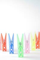 a pile of colorful clothes pegs on a white surface photo