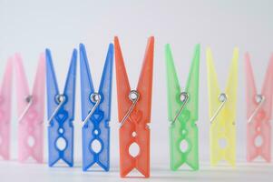 a pile of colorful clothes pegs on a white surface photo