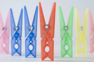 a pile of colorful clothes pegs on a white surface photo