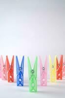 a pile of colorful clothes pegs on a white surface photo