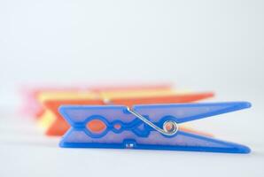 a pile of colorful clothes pegs on a white surface photo