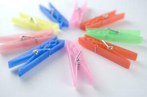 a pile of colorful clothes pegs on a white surface photo