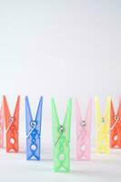 a pile of colorful clothes pegs on a white surface photo