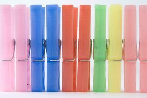 a pile of colorful clothes pegs on a white surface photo