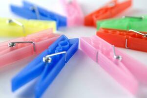 a pile of colorful clothes pegs on a white surface photo