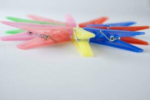 a pile of colorful clothes pegs on a white surface photo