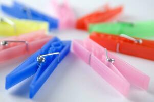 a pile of colorful clothes pegs on a white surface photo