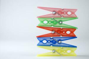 a pile of colorful clothes pegs on a white surface photo
