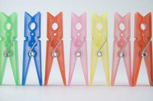 a pile of colorful clothes pegs on a white surface photo