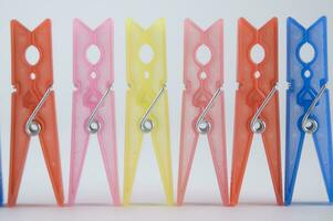 a pile of colorful clothes pegs on a white surface photo