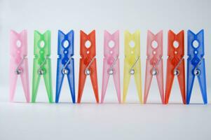 a pile of colorful clothes pegs on a white surface photo