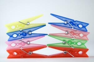 a pile of colorful clothes pegs on a white surface photo