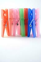 a pile of colorful clothes pegs on a white surface photo