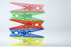 a pile of colorful clothes pegs on a white surface photo