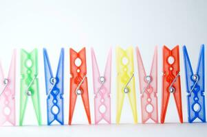 a pile of colorful clothes pegs on a white surface photo