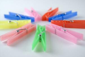 a pile of colorful clothes pegs on a white surface photo