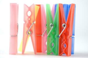 a pile of colorful clothes pegs on a white surface photo