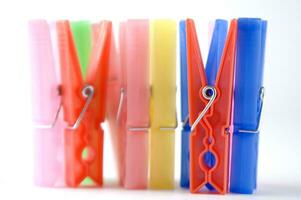 a pile of colorful clothes pegs on a white surface photo