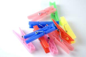 a pile of colorful clothes pegs on a white surface photo