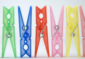 a row of colorful clothes pegs with a single clothespin photo