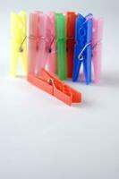 a pile of colorful clothes pegs on a white surface photo