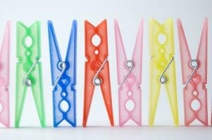 a pile of colorful clothes pegs on a white surface photo