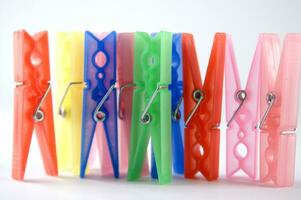 a pile of colorful clothes pegs on a white surface photo