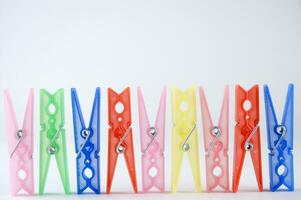 a row of colorful clothes pegs with a single clothespin photo