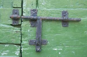 a close up of a green door with a latch photo