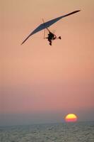 a hang glider is flying in the air photo