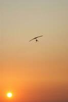 a hang glider is flying in the air photo