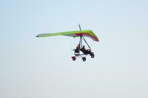 a person flying a hang glider in the sky photo