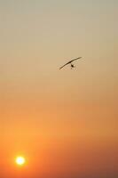 a hang glider is flying in the air photo