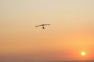 a hang glider is flying in the air photo