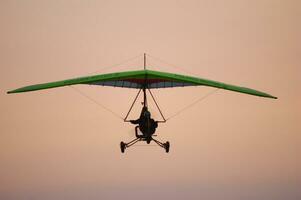 a person flying a hang glider in the sky photo