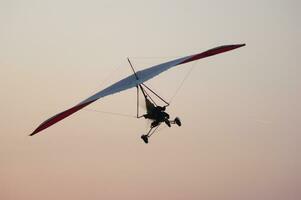 a person flying a hang glider in the sky photo