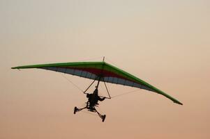 a hang glider is flying in the air photo