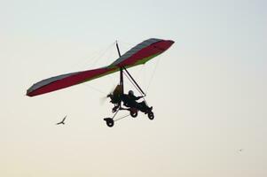 un colgar planeador es volador en el aire foto