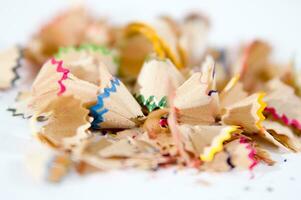 a pile of colored pencils on a white surface photo