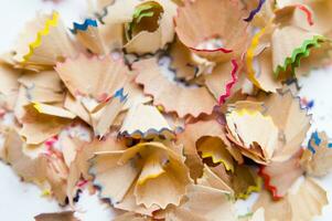 a pile of colored pencils on a white surface photo