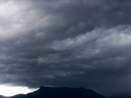 a large dark cloud is seen over a body of water photo