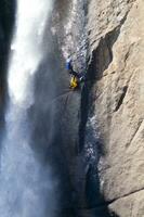 un persona en un cuerda alpinismo arriba un cascada foto