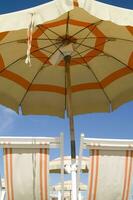 two lounge chairs under an umbrella photo