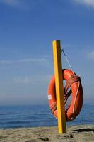 a life preserver on a pole on the beach photo