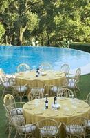 a table set for dinner near a pool photo