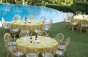 a table set for dinner near a pool photo